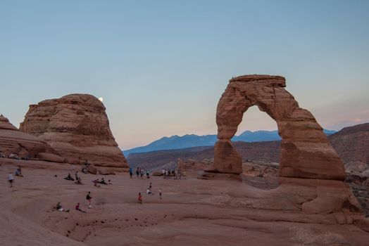 Delicate Arch in Arches National Park Utah at sunset with pastel sky.