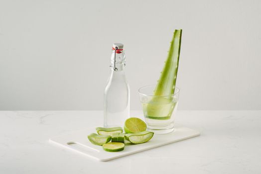 fresh aloe vera leaves and aloe vera juice in bottle glass on white background