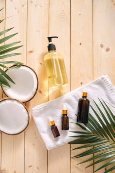 Cracked coconut and a bottle of oil on the table - spa, skincare, haircare and relaxation concept 