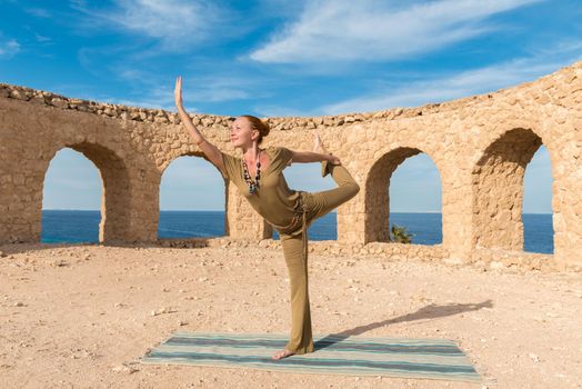 Woman doing yoga asana at exotic ancient location