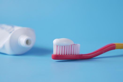 tooth brush with paste on blue background