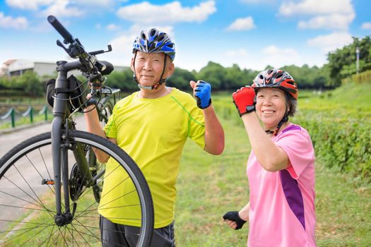 Happy healthy senior couple exercising with bicycles
