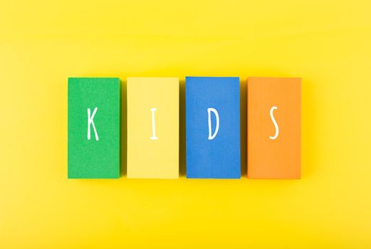 Word kids on colorful rectangles against bright yellow background