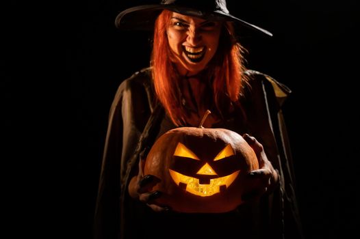 Wicked witch holding a jack-o-lantern for halloween