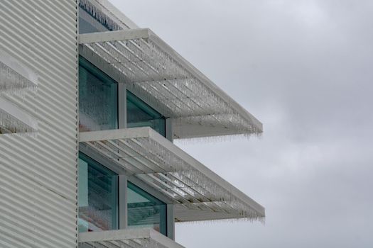 Icicles of freezing rain over weather shelds of an office building