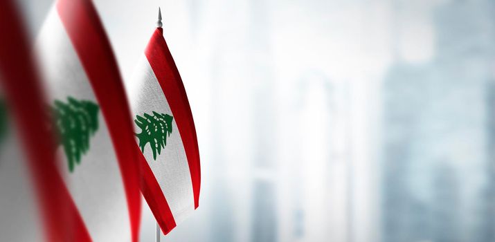 Small flags of Lebanon on a blurry background of the city