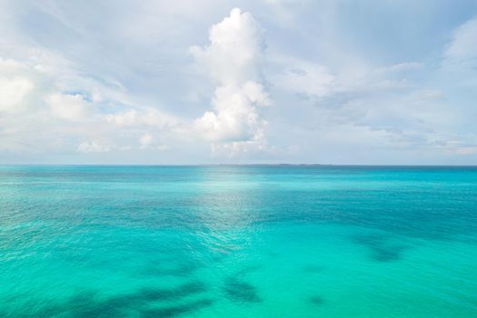 Caribbean sea surface water and sky background. Exotic landscape with clouds on horizon. Natural tropical paradise. Travel tropical island resort.