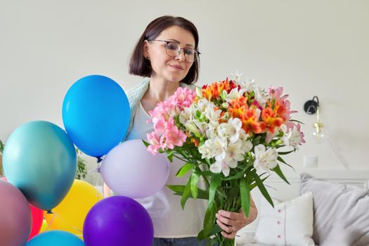 Birthday, 45 years old, happy female with bouquet of flowers and balloons