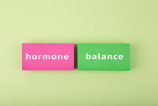 Simple hormone balance concept in bright green and pink colors