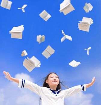 Excited student girl throwing books fly in the air