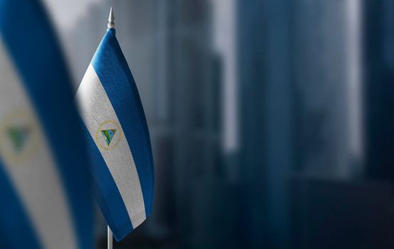 Small flags of Nicaragua on a blurry background of the city