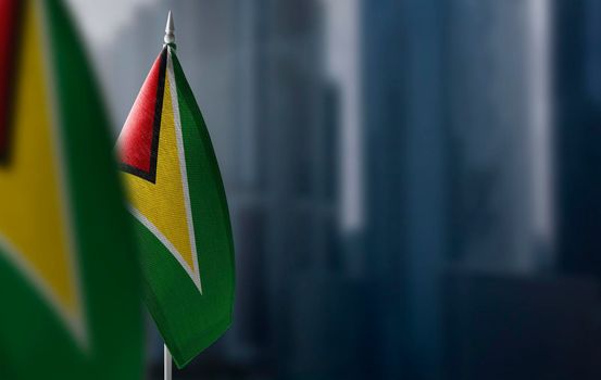 Small flags of Guyana on a blurry background of the city