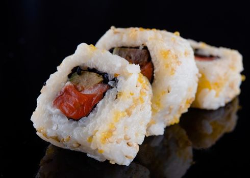 closeup of sushi on a black  background with reflect