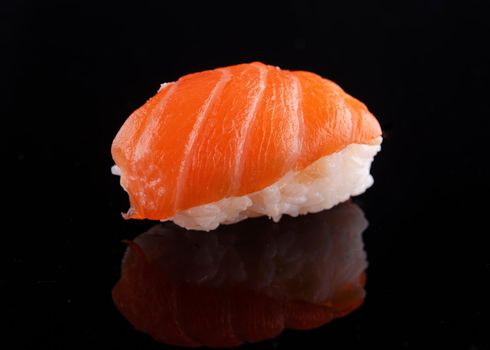 closeup of sushi on a black  background with reflect
