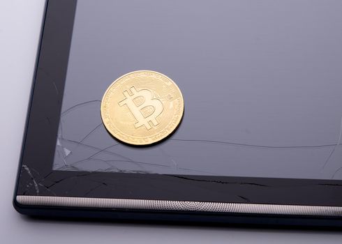 bitcoins on a broken tablet screen