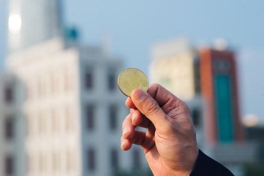 Hand holding a bitcoin coin