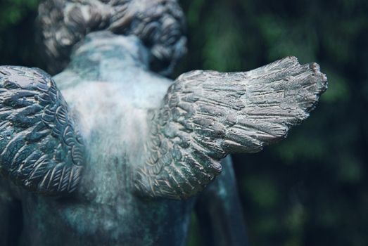 Angel wings. Fragment of bronze sculpture at old cemetery.