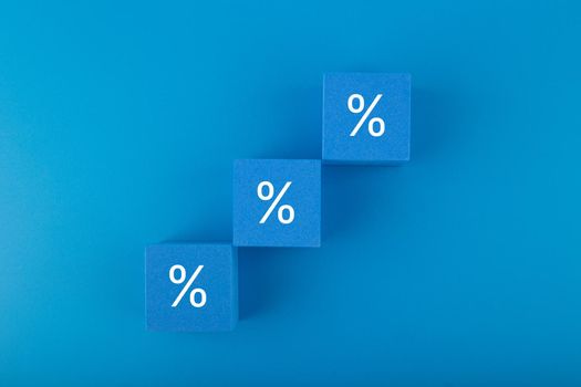 Toy blocks as a ladder with percentage sign on dark blue background