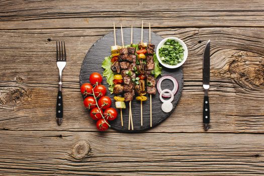 delicious meat skewer black slate with fork butter knife wooden table. High quality beautiful photo concept