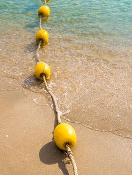 Floating buoy and rope dividing the area on the beach