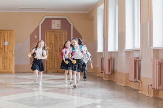 cheerful kids running school corridor
