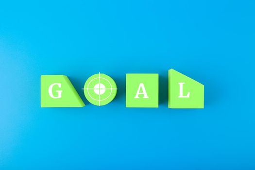 Goal single word written on green geometric figures on blue background