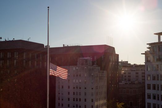 US flag flying at half mast during sunset in Washington DC