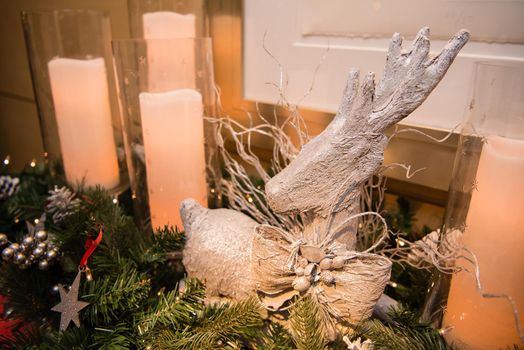 White reindeer decoration with candles and garland.