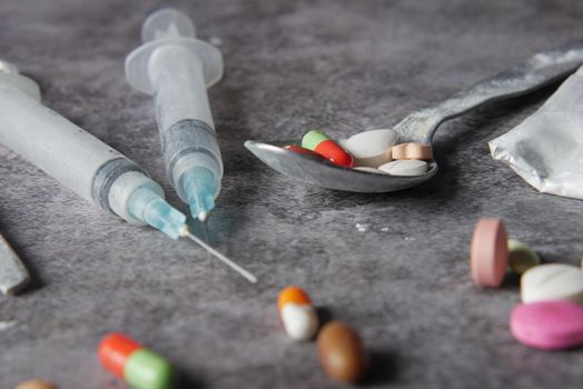 drug addiction concept with heroine packet and syringe on black backgrund