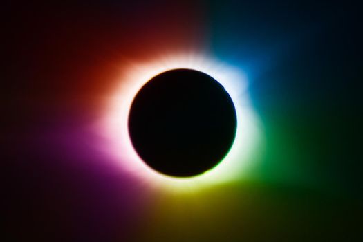 Solar eclipse with rainbow of colors and a black center