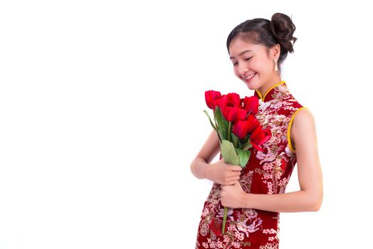 Young Asian beauty woman wearing cheongsam and holding red rose gesture in Chinese new year and Valentines festival event on isolated white background. Love festival and Lifestyle concept. Qipao dress