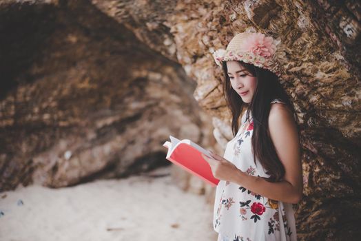 Beauty Asian woman reading book at beach. Lifestyles and Nature concept. Relaxation and leisure concept. Summer and tropical theme.