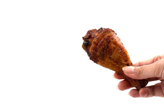 Hand catching roasted chicken leg. delicious grill chicken on foil on isolated white background. Food and appetizer concept