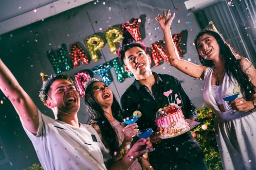 Asian friends having fun in birthday party at night club with birthday cake. Event and anniversary concept. People lifestyles and friendship.