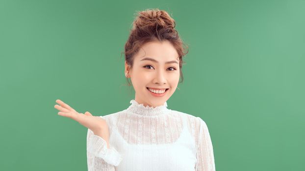positive girl promoter point index finger copyspace indicate adverts promotion isolated over green color background