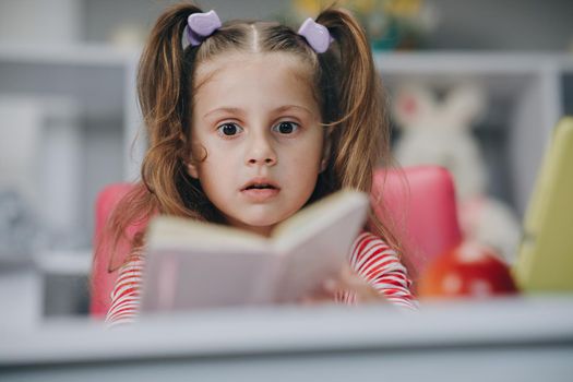 Cute little girl reading a book