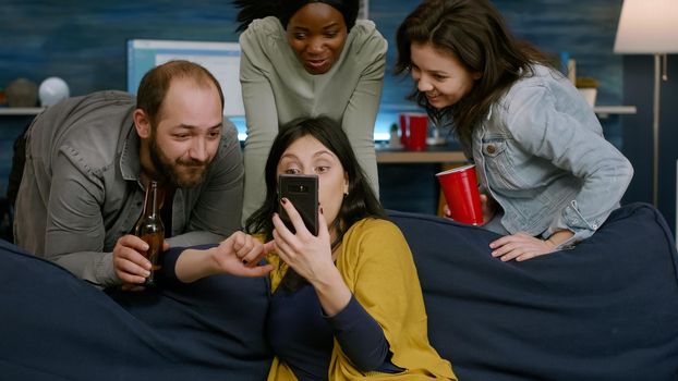 Woman showing comedy video to her multiracial friends socializing together