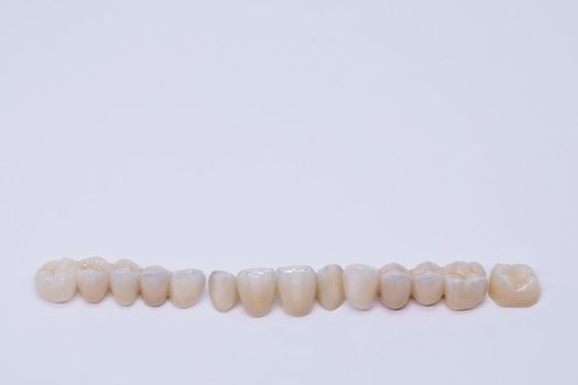 Dental bridge isolated on wite made of ceramic porcelain. Aesthetic restoration of tooth loss. Ceramic zirconium. Metal Free Ceramic Dental Crowns.