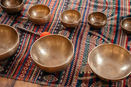 Tibetan handcrafted singing bowls on the floor in yoga class, sound therapy concept