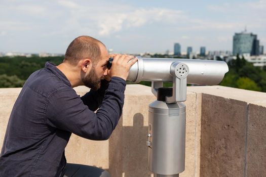 Man wathching through binoculars telescope