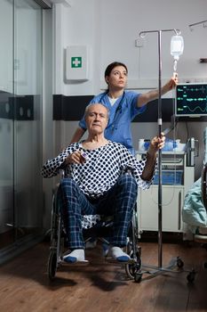 Medical practitioner preparing senior sick hospitalized man