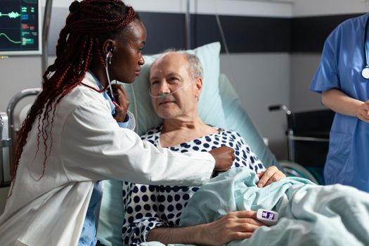 African american cardiologist checking examining senior patient heart