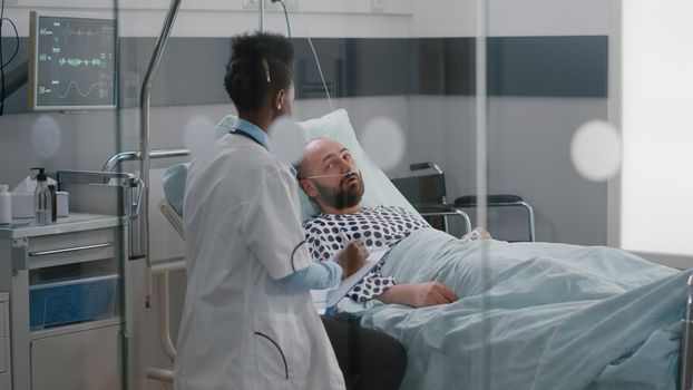 Afro american doctor checking sick man monitoring sickness symptom