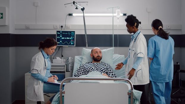 Patient discussing with doctors while resting in bed during medical recovery