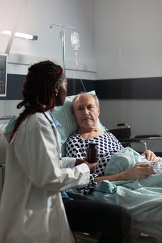 African american therapist in hospital room discussing treatment