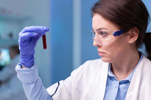 Scientist doctor in white coat discovering genetic infection and analysing a blood tube