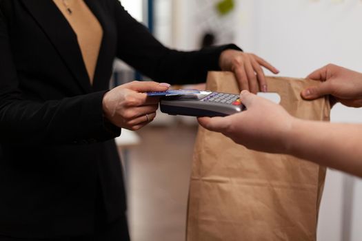 Close up of business woman holding credit card of pos