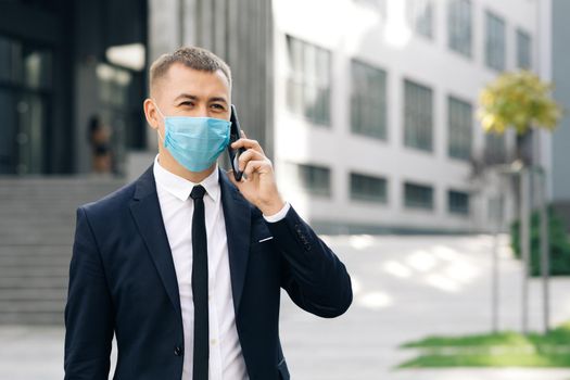 Caucasian young businessman in medical mask talking on phone. COVID-19 Coronavirus Infection. Face mask Covid-19. Epidemic Coronavirus Mers. Human Masked 2019-ncov