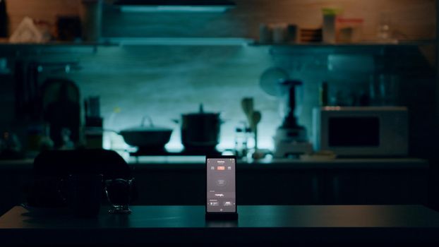 Phone with intelligent software placed on table in kitchen with nobody in