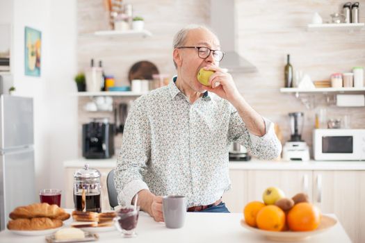 Elderly man bitting green apple
